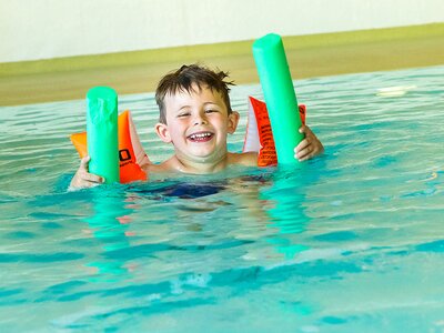 Kind beim Schwimmen mit Schwimmnudel