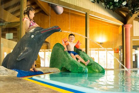 Kinder spielen im Kinderbecken