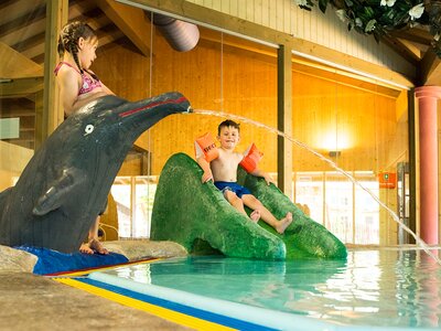 Mädchen und Junge spielen im Kinderbecken