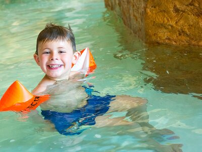 Junge mit Schwimmflügel im Wasser