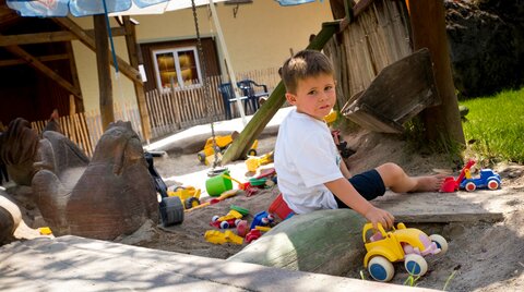 Junge spielt am Sandspielplatz