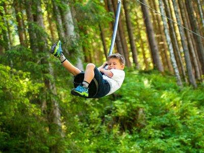 Junge auf Kinderseilbahn