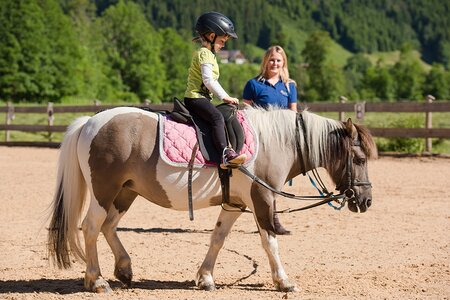 Mädchen auf Pferd auf dem Reitplatz