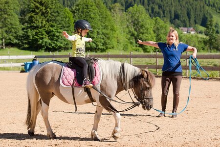 Mädchen und Lehrerin beim Reitkurs