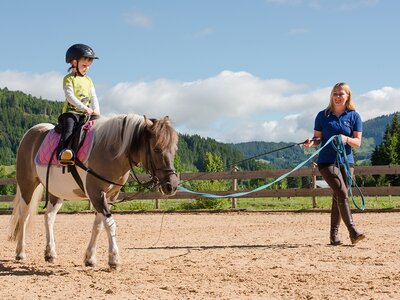 Mädchen mit Reitlehrerin beim Reitkurs