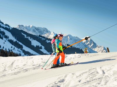 Kinder fahren mit dem Skilift